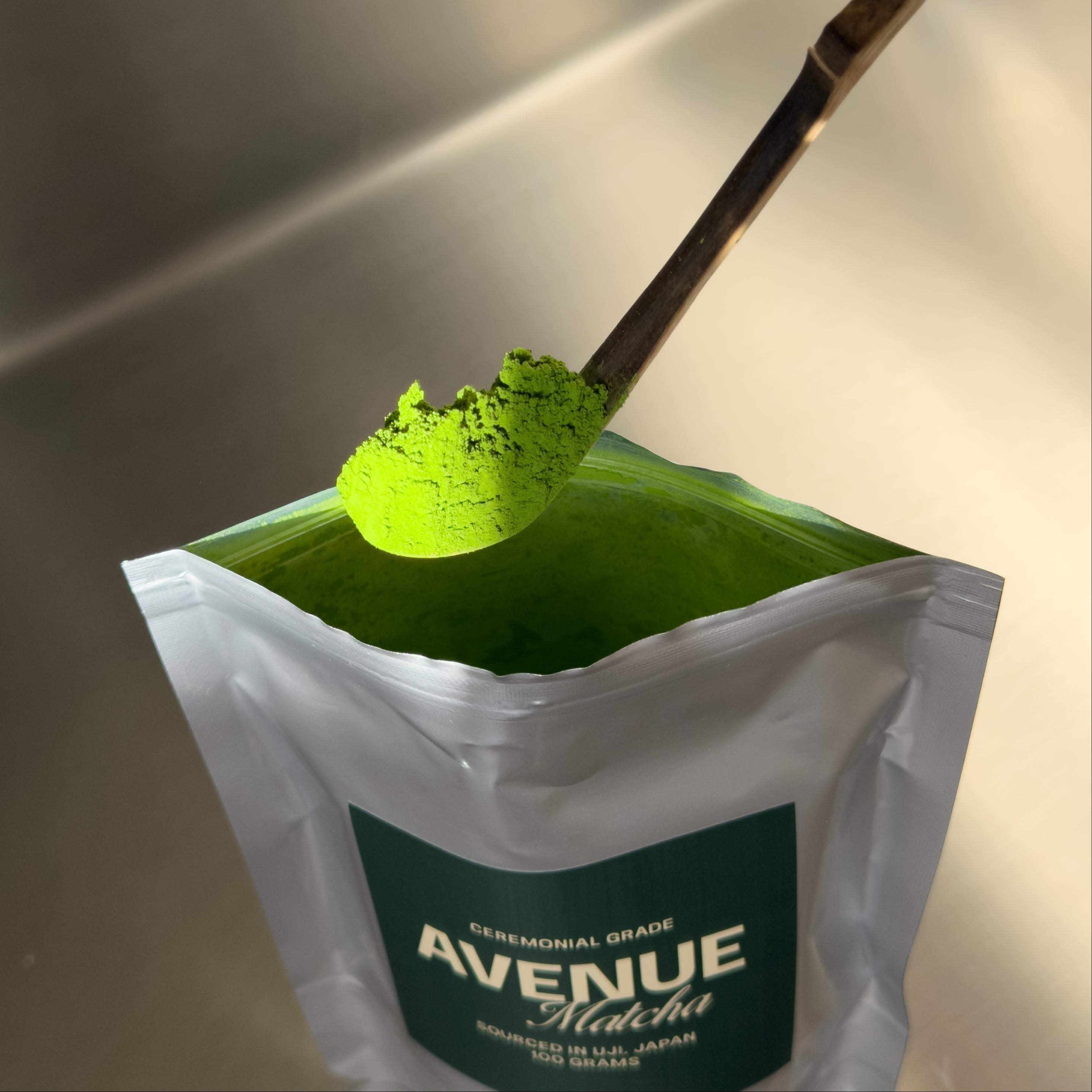 A package of Avenue Matcha with a spoonful of green powder on top.