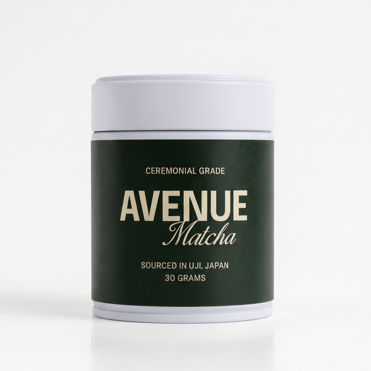 A white cylindrical canister of Avenue Matcha ceremonial grade matcha, featuring a dark forest green label with gold lettering, set against a clean white background.